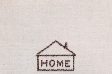 Home sign from coffee beans isolated on linea texture, aligned bottom center.