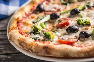 Irtalian pizza with broccoli spinach tomatoes olives and mozzarela or parmesan cheese. Mediterranean vegetarian meal