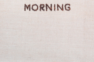 Morning letter sign from coffee beans isolated on linea texture, aligned top center.