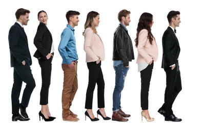 side view of seven different people waiting in line