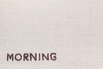 Morning letter sign from coffee beans isolated on linea texture, aligned bottom left.