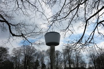 VIERSEN, GERMANY - MARCH 27. 2019: View on 55 meter high water tower through bare branches. Tower...
