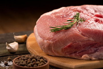 Pork meat with seasonings on wooden background.