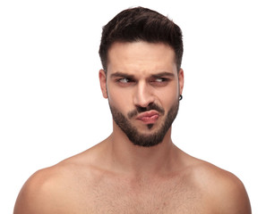 Obraz premium goofy undressed guy with beard looking away curious