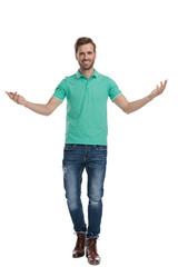 man in green polo shirt welcomes with hands