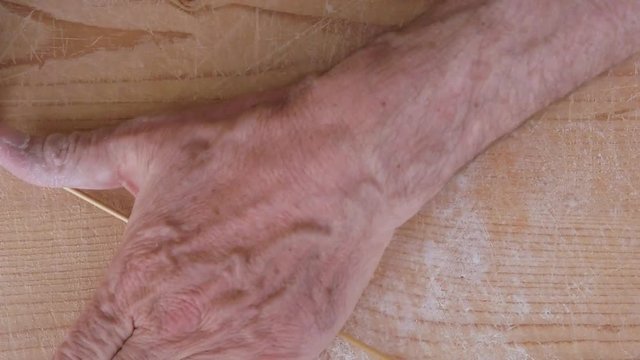 Pasta fatta in casa su un tagliere di legno con farina bianca e integrale.