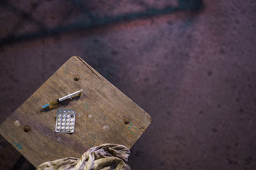 Grabbing filled syringe on a table - Anxiety, depression and danger feeling - Pack of narcotic pills