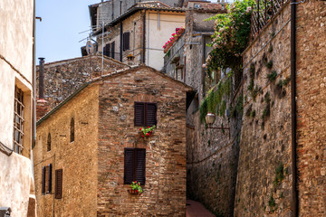 Fototapeta na wymiar Beautiful view of cozy street of San Gimignano and Old Town of medieval town in the sunny day. Tuscany, Italy.