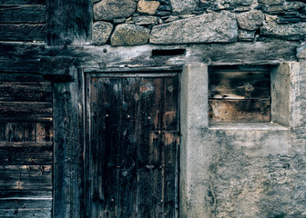 Ancient wooden door in stone wall Swiss Chalet.