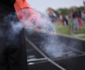 Obraz premium A starter gun signals the final lap in a high school track meet