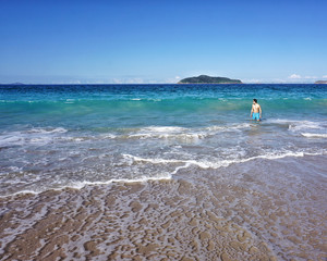 Asian man on the beach with waves and island in the background blue sky on holidays Port Stephens