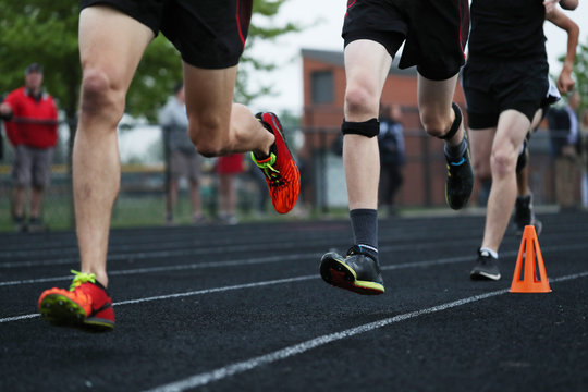 Boys Run Around A Track, Competing In A High School Track Meet