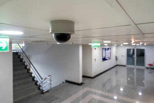 CCTV ip camera hang on the ceiling looking at the stair and access control door for high security safety