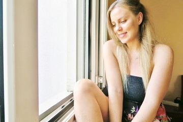 girl sitting near the window and cute smiling