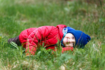 Fototapeta na wymiar small child lying on the green grass