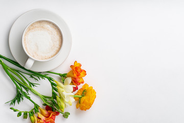 Flatlay with freesia flowers, capuccino cup and copy space on white background