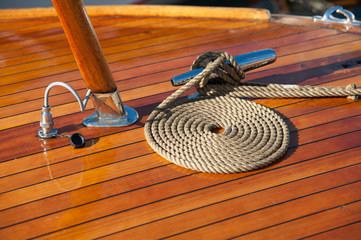 Rope neatly coiled on the wooden deck of a boat.