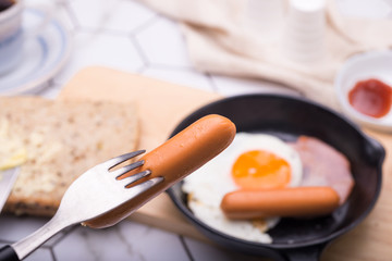 breakfast in pan with fried eggs, sausages, bacon, toasts and coffee