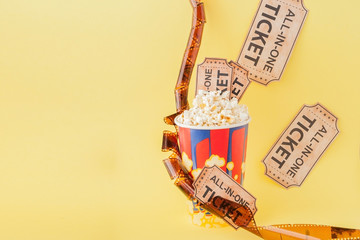 Movie tickets, film strips and popcorn on blue background. Copy space for text