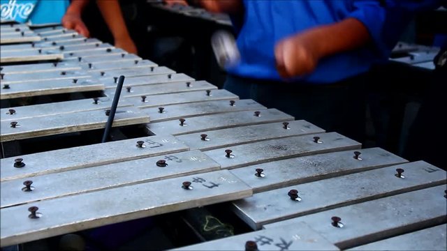 Close up video shot of hands of members of a marching band playing the lyre or xylophone