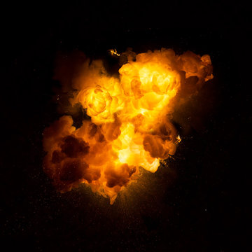 Realistic fiery explosion with sparks over a black background