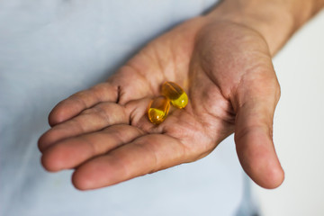  fish oil capsules in man's hand