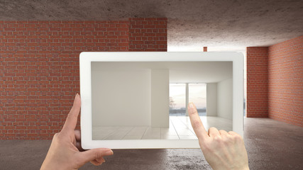 Augmented reality concept. Hand holding tablet with AR application used to simulate furniture and design products in an interior construction site, empty interior with parquet floor