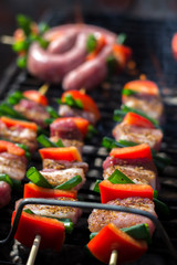 Close up pf delicious chicken breast on wooden skew with fresh vegetables, garlic, paprika fried on mangal barbeque grill and smoke