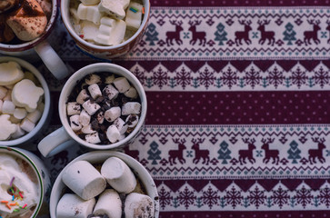 Cups of hot cocoa with marshmallows and cream against Christmas background. Winter time. Toned image. Copy space for your text.