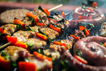 Close up pf delicious chicken breast on wooden skew with fresh vegetables, garlic, paprika fried on mangal barbeque grill and smoke