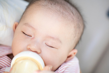 Asian baby happy in the room.Asian baby girl lying down on bed .
