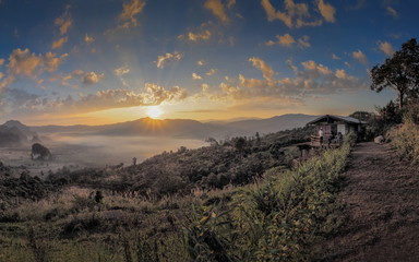 sunrise at Phu Langka Photo Corner View Point, view scenic sea of fog in valley around with high mountains with yellow sun light and cloudy sky background, route 1148, Phayao, northern of Thailand.
