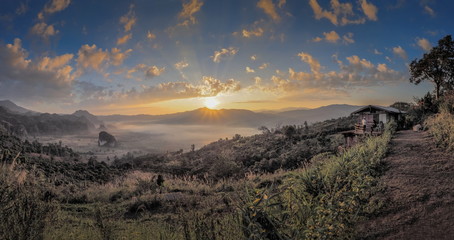 sunrise at Phu Langka Photo Corner View Point, view scenic sea of fog in valley around with high mountains with yellow sun light and cloudy sky background, route 1148, Phayao, northern of Thailand.
