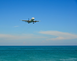 Fototapeta na wymiar Airplane landing over the sand beach