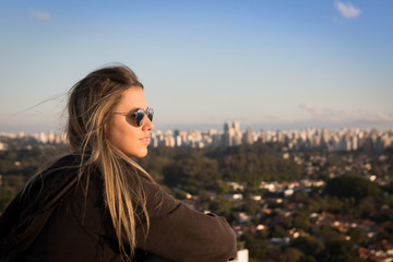 Beautiful girl sitting on top of a building