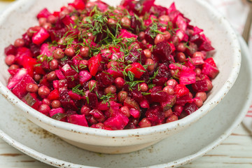 Vinaigrette is a traditional Russian and Ukrainian vegetable salad of beets, carrots, potatoes, pickles, green peas and dill. Vegetarian diet dish. Selective focus