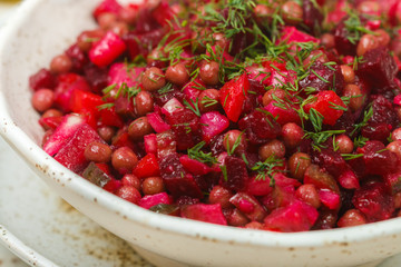Vinaigrette is a traditional Russian and Ukrainian vegetable salad of beets, carrots, potatoes, pickles, green peas and dill. Vegetarian diet dish. Selective focus