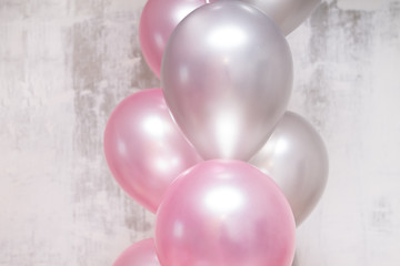 bunch of silver and pink balloons on gray concrete background