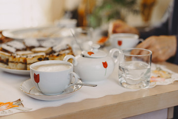 Warm coffee in a cup and cake on the table. Retro stylized photo. 