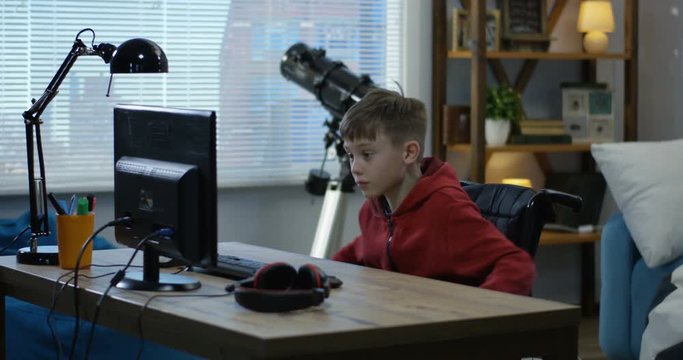 Wheelchaired boy using computer