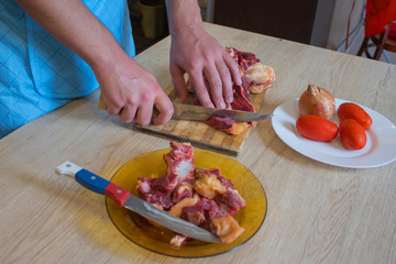 Obraz na płótnie Canvas Butcher cutting meat on kitchen. Man in the kitchen cutting a piece of meat