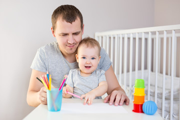 young father and little girl drawing with colored pencils