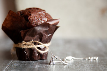 Homemade chocolate muffin on the wooden table.