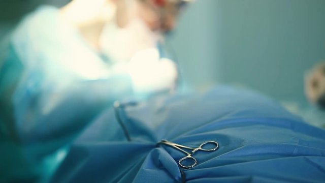 surgical instrument tweezers scissors on a patient against the background of a medical operation