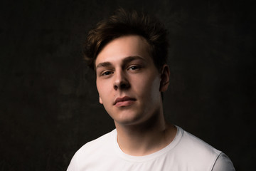 Fototapeta premium Handsome young man on black background looking at camera.
