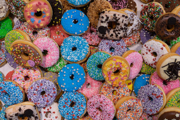 Fototapeta na wymiar Delicious colored donuts in the shop window