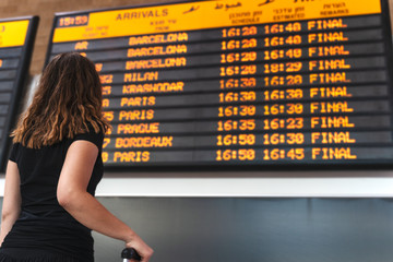 young woman checking the timetable at the airport