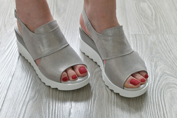 Naklejka premium The Womens legs in summer white sandals