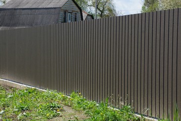 long gray brown metal fence outside in green grass