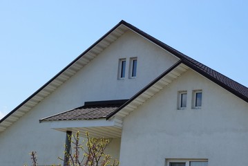 two gray lofts with windows against a blue sky